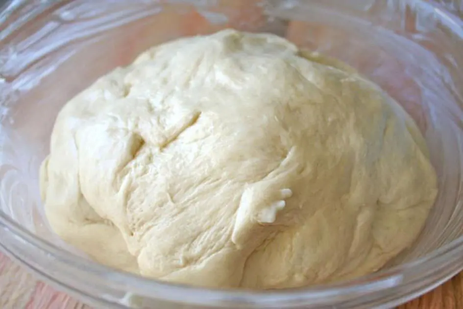 A delicious bowl of dough made from Gold Medal Flour ready to be transformed into mouthwatering treats, resting in a sturdy table.